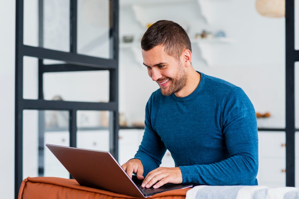 A Smiley man using laptop from Home working in a social media marketing Agency Blaze Creative